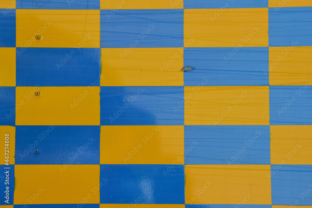 Checkered blue and yellow dirty fabric texture, top view