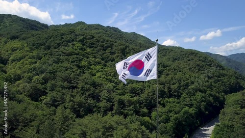 Aerial view of Korean flag waving in the wind in the background of the forest, Korean flag is Taegeukgi.
대한민국 국기, 태극기. photo