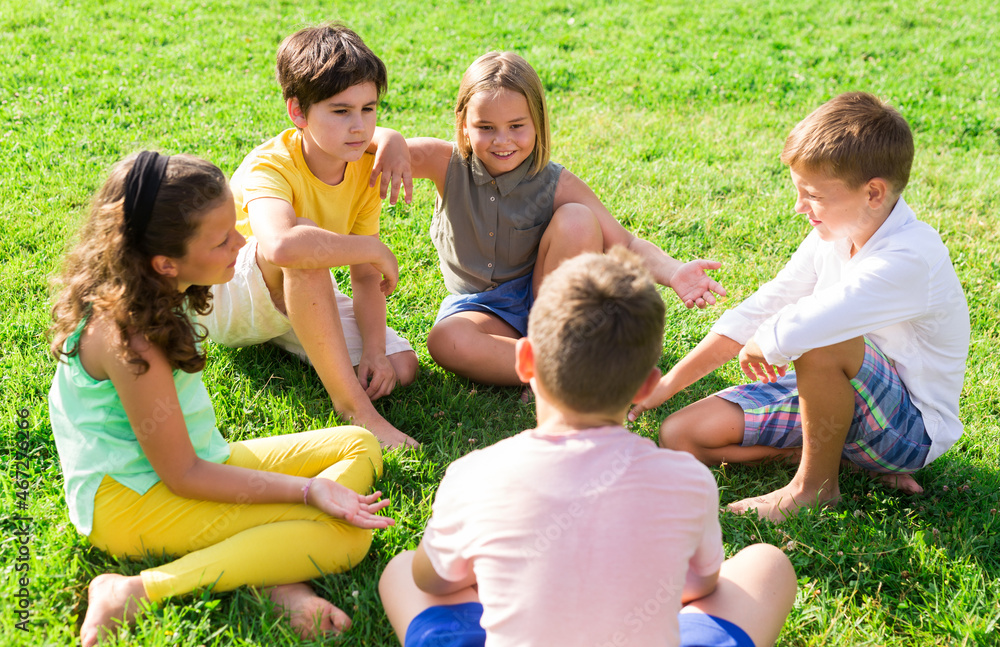 Fototapeta premium Positive preteen childs, boys and girls, standing at a park in summer outside