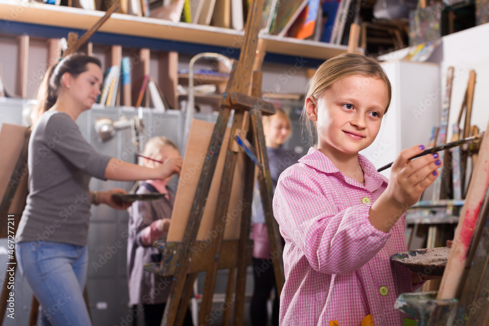 Smiling italian schoolgirls diligently training their painting skills during class at art studio