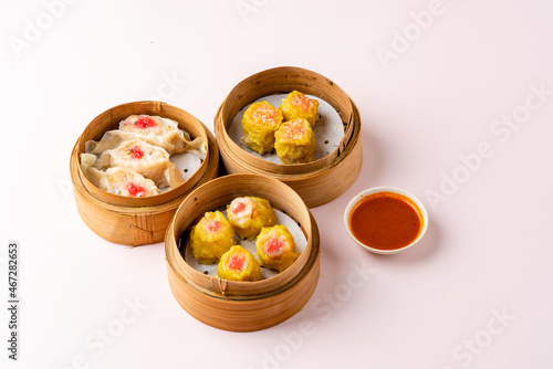 Top View of Assorted Chinese Dimsum in bamboo basket. Dimsum is a large range of small dishes that Cantonese people traditionally enjoy in restaurants for breakfast and lunch.