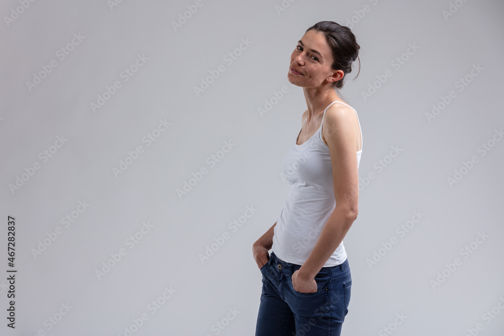 Playful attractive trendy young woman grinning at the camera Playful attractive trendy young woman grinning at the camera