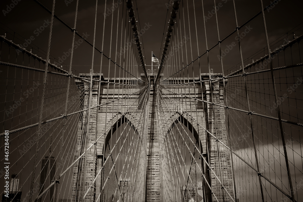 Obraz premium Closeup of the cables and pointed arches above the passageways through the stone towers of the Brooklyn bridge in New York City, USA