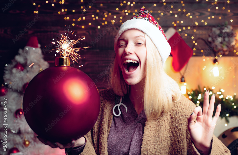Christmas woman hold bomb. Crazy merry Christmas and Happy New Year. Crazy comical face. Young funny woman wink. Comic grimace. Christmas woman hold bomb. Crazy merry Christmas and Happy New Year. Crazy comical face. Young funny woman wink. Comic grimace.
