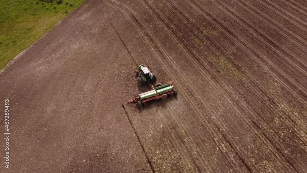 Acending top down shot of industrial tractor Plowing Corn Crop Field - Agriculture Machinery Acending top down shot of industrial tractor Plowing Corn Crop Field - Agriculture Machinery
