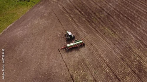 Acending top down shot of industrial tractor Plowing Corn Crop Field - Agriculture Machinery photo