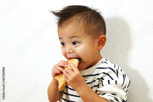 日本のスイーツ、鯛焼きを美味しく食べている男の子。