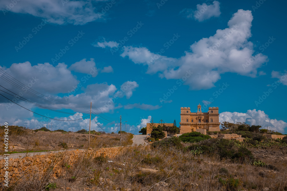 View of Selmun palace in malta from Afar. Frontal view of a palace seen from a distance, strong frontal view of majestic facade.