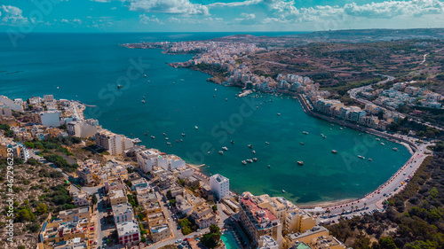 Aerial drone panorama of Saint paul bay in Malta on a sunny autumn day. Famous st. paul's bay, view of harbor and beach.