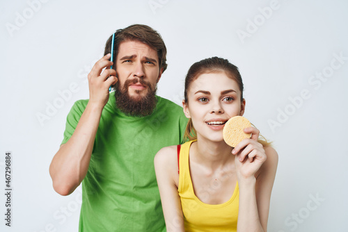 young couple in multicolored t-shirts in the bathroom grooming