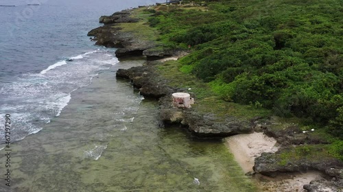 Aerial drone pan shot, coastline with ocean waves hitting the rocky shore in Xiaoliuqiu Lambai Island, Pingtung county, Taiwan. photo