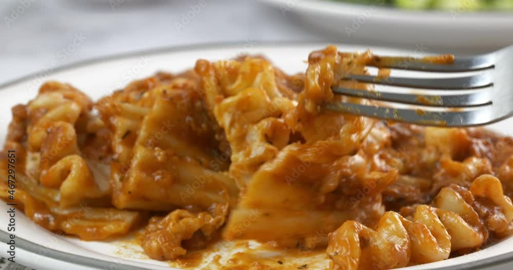 Eating a forkful of lasagna close up slow motion Eating a forkful of lasagna close up slow motion