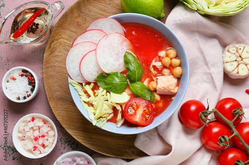 Bowl with tasty homemade pozole soup and ingredients on color background