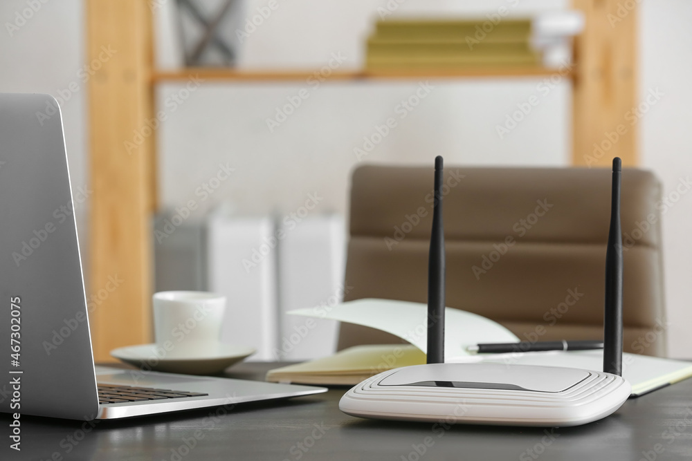 Modern wi-fi router on table in office Modern wi-fi router on table in office