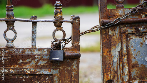 Fotografie Rusty old padlock on metal gate closeup