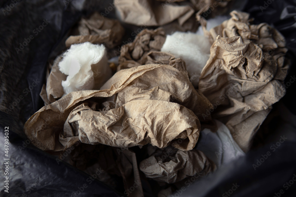 Closeup pile Used recycled unbleached crumpled brown craft tissue in black bin plastic bag background Closeup pile Used recycled unbleached crumpled brown craft tissue in black bin plastic bag background