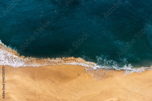 Lonely beach view from above. Sandy beach with blue sea. Beautiful seascape, beach on the island of Nusa Penida, Indonesia. The sea coast with yellow sand and blue ocean. Clean coast. Copy space