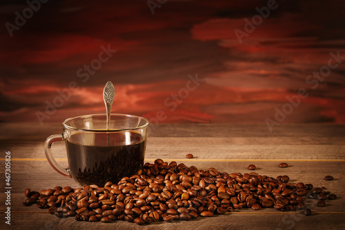 Cup of black coffee with coffee beans on the table photo