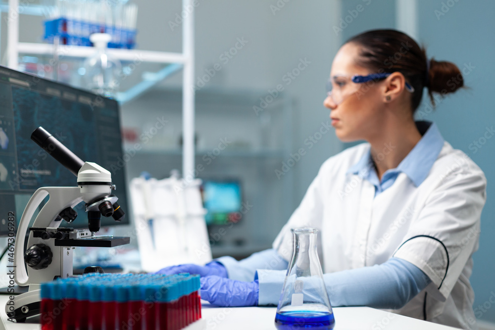 Specialist woman doctor analyzing virus infection typing medical expertise on computer working at healthcare vaccine in biochemistry hospital laboratory. Biologist developing medical treatment Specialist woman doctor analyzing virus infection typing medical expertise on computer working at healthcare vaccine in biochemistry hospital laboratory. Biologist developing medical treatment