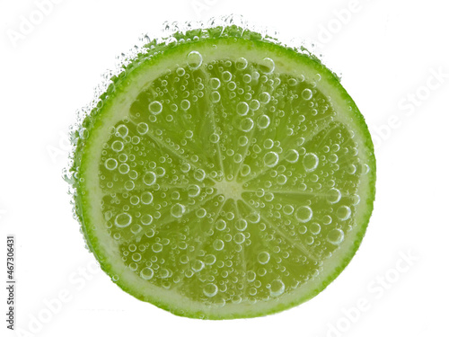Lime slice in sparkling water, close up, isolated on a white background.