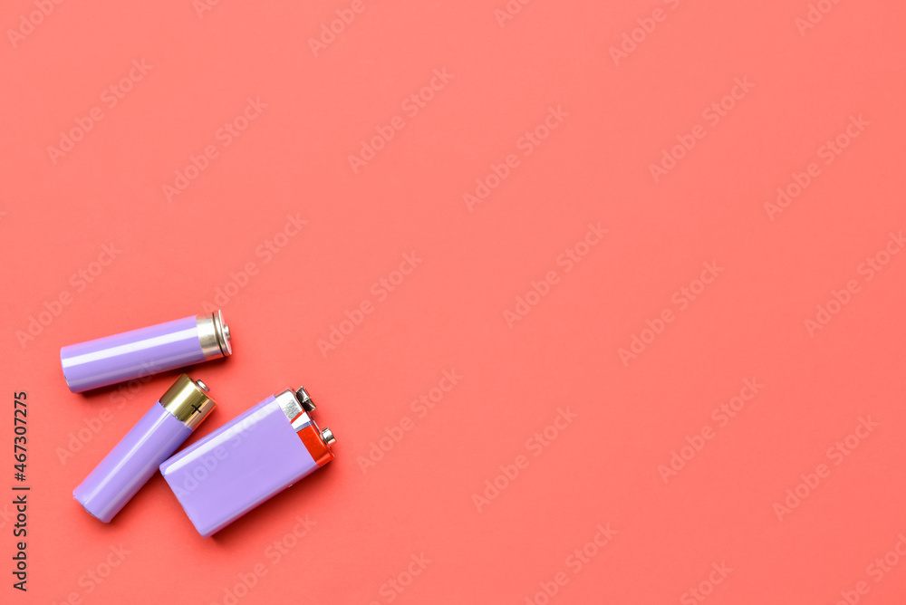 Alkaline batteries on red background, top view Alkaline batteries on red background, top view
