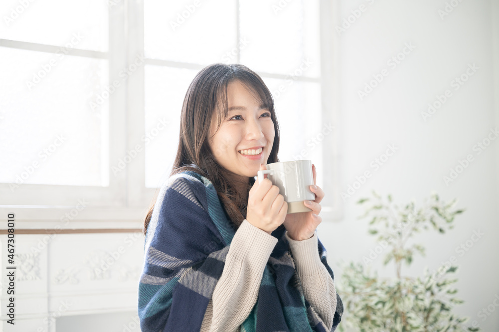 Asian (Japanese) woman relaxing with a cup of coffee in a white room that looks like a new house Copy space Asian (Japanese) woman relaxing with a cup of coffee in a white room that looks like a new house Copy space