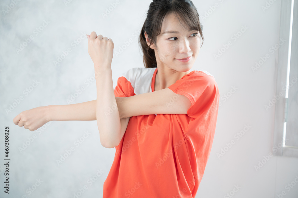 Beautiful Asian (Japanese) woman preparing for a workout, looking at camera, copy space Beautiful Asian (Japanese) woman preparing for a workout, looking at camera, copy space