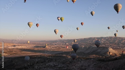 hot air balloons fly over beautiful valleys at dawn in Cappadocia