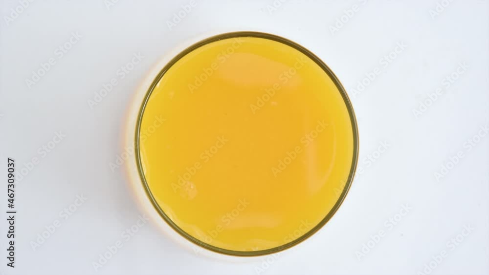 Stop motion animation of a glass of orange juice filling up overhead view Stop motion animation of a glass of orange juice filling up overhead view
