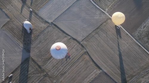 hot air balloons fly and sit down on ground over beautiful valleys at dawn in Cappadocia