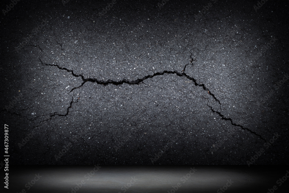 black wall with a crack with a concrete floor, background for placing ...