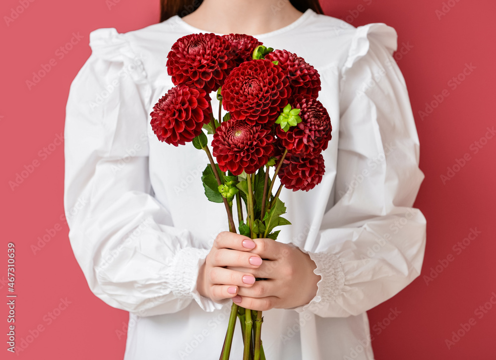 Woman holding bouquet of beautiful dahlia flowers on color background Woman holding bouquet of beautiful dahlia flowers on color background