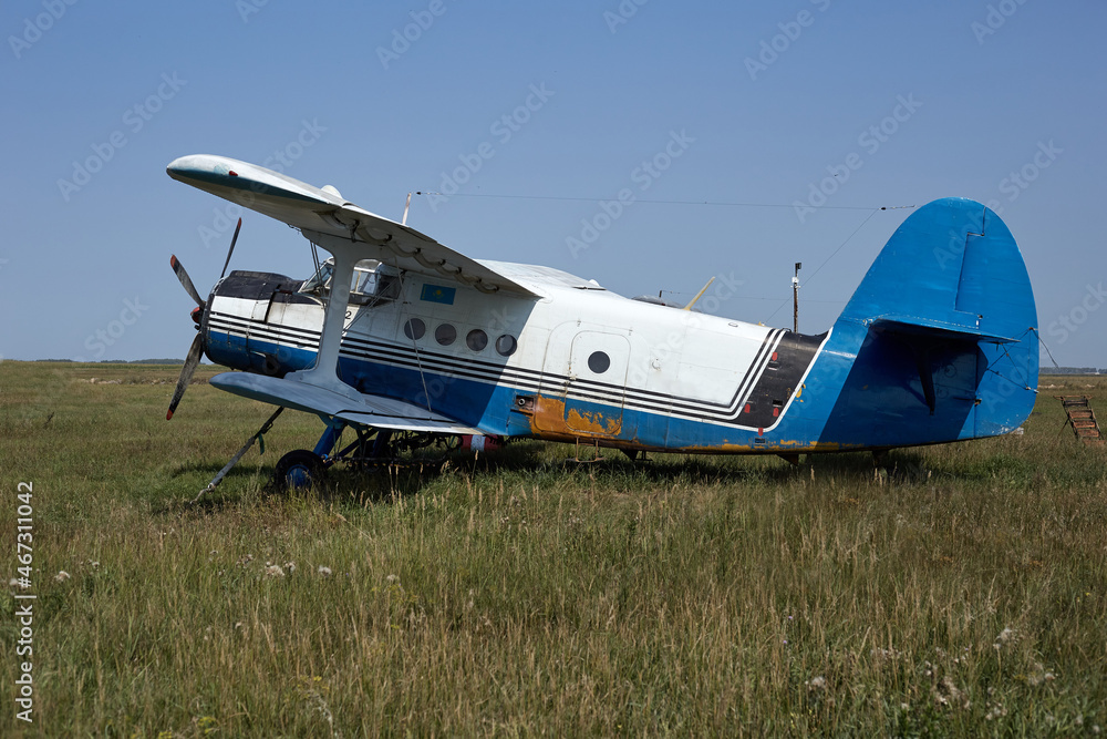 The old plane is at the airfield in a green field in good condition can fly The old plane is at the airfield in a green field in good condition can fly