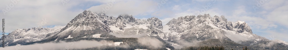 Obraz premium Wilder Kaiser in Tirol Österreich mit ersten Schnee im Jahr umhüllt von Wolken und Nebelschwaden Panorama