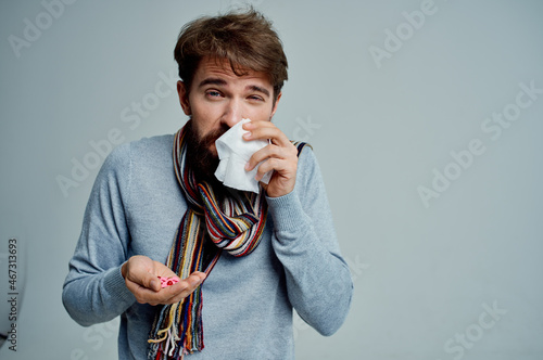 Tela cold man in a sweater with a handkerchief infection light background
