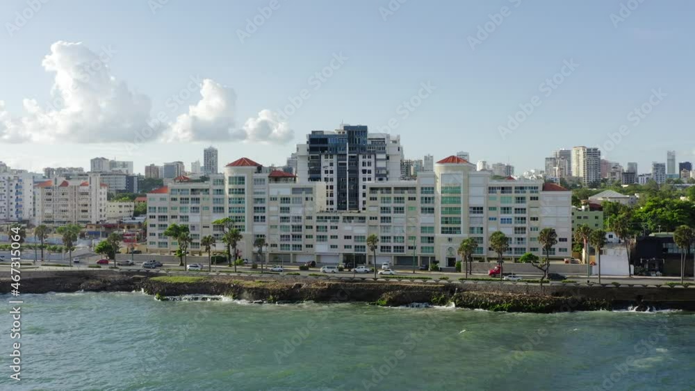 Car traffic on road along Malecon seafront and cityscape in background, Santo Domingo. Aerial sideways Car traffic on road along Malecon seafront and cityscape in background, Santo Domingo. Aerial sideways