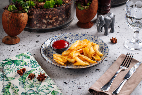 Fried potato wedges with ketchap snack on decorated background photo