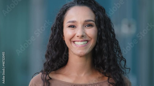 Close-up of satisfied happy Hispanic female young face. Arab carefree contented cheerful girl looking at camera nods waving head answering yes consent agree positive opinion answers nod agreement