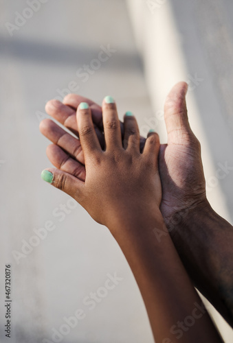 Vertical shoot of two hands touching one each other of dominican father and daughter