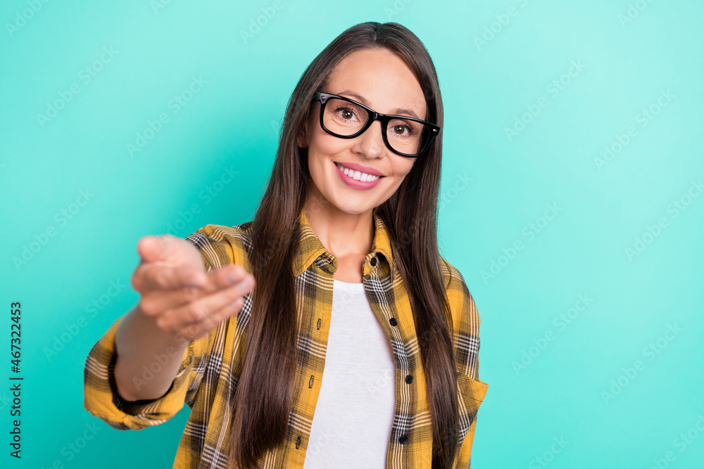 Photo of optimistic young lady invite you wear spectacles yellow shirt isolated on turquoise color background Photo of optimistic young lady invite you wear spectacles yellow shirt isolated on turquoise color background