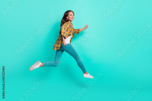 Full size profile photo of mature sweet brunette lady run wear shirt jeans shoes isolated on turquoise background