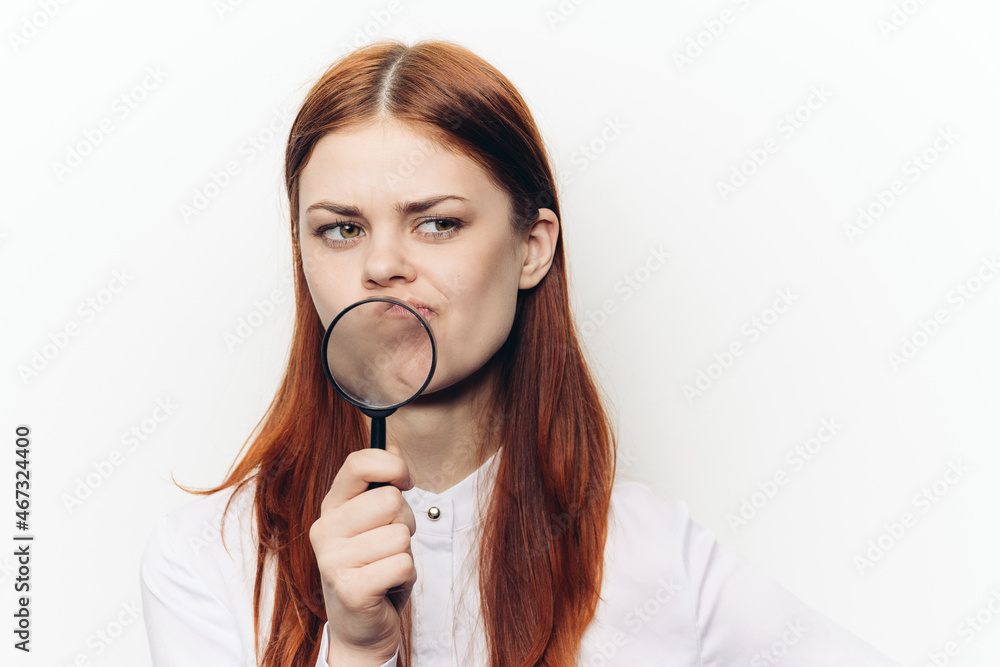 pretty woman grimacing with magnifying glass near face pretty woman grimacing with magnifying glass near face