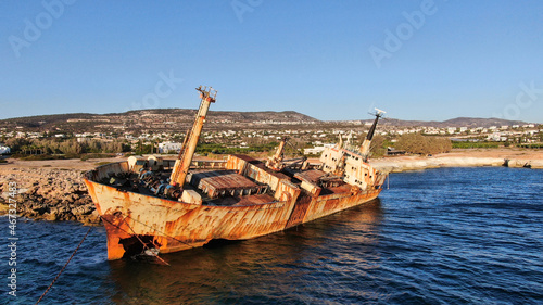 A sunken iron ship off the coast covered with rust. View from the sea to the shore.