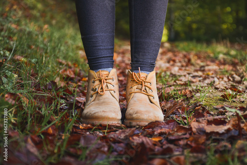 close up view of a woman legs wearing mountain boots, autumn leaves background © Lara Sanmarti