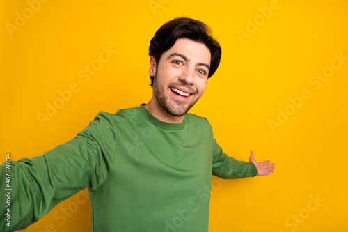 Photo of hospitable guy hand show empty space invitation wear green sweater isolated yellow color background