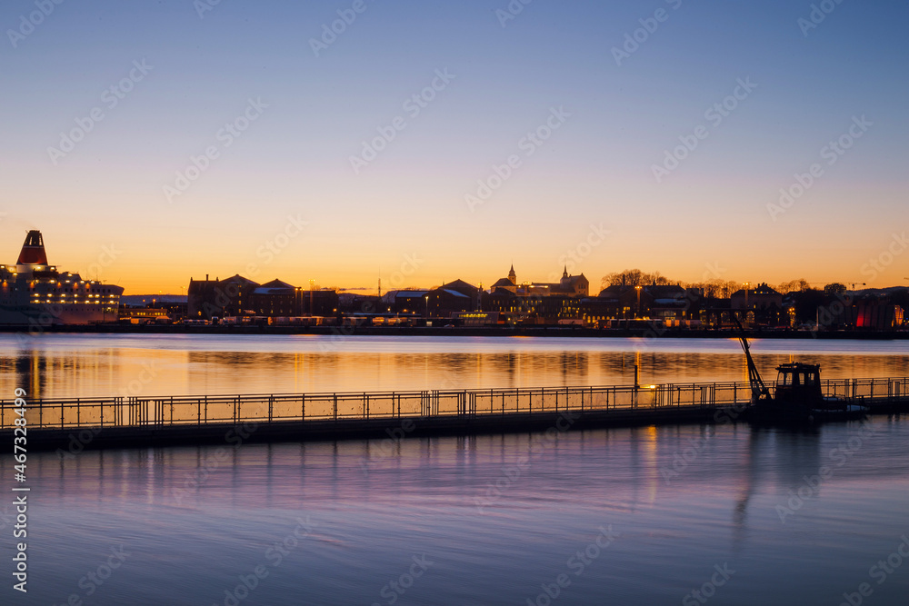 Scenic view of Oslo city coast with houses and buildings on twilight. Calm bay at dusk