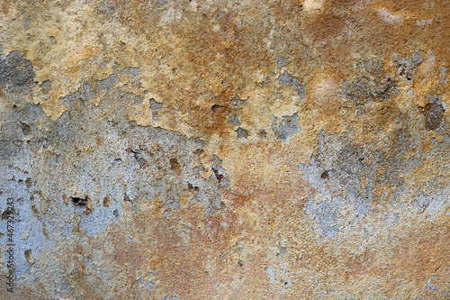 golden wall with rough texture and chipped yellow painting with moisture - weathered surface for a dystopian background