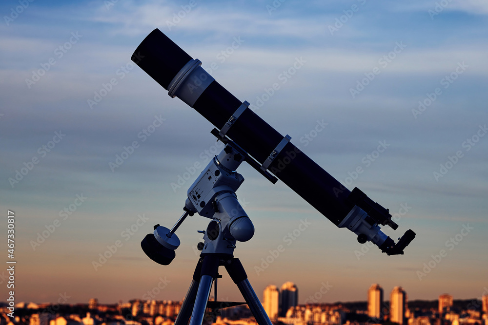 Big astronomical telescope under a twilight sky ready for stargazing.