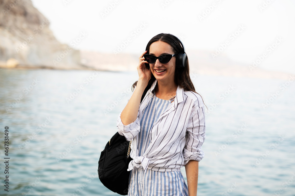 Hot woman relaxing on the sandy beach. Beautiful woman with headphones listening the music. Hot woman relaxing on the sandy beach. Beautiful woman with headphones listening the music.