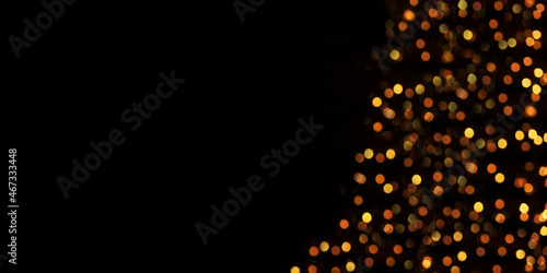 Black background with colorful and golden light effects. Horizontal background with blur bokeh effects for christmas time. Christmas concept with space for text. Banner